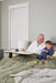 An older man and a child sitting together on a bed with a breakfast tray